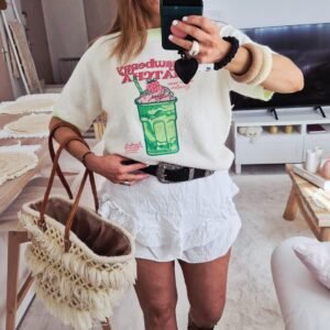 Une femme porte un pull bohème manches courtes tendance très doux à motifs moitos pour l'été mi saison