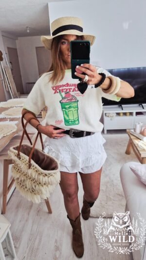 Une femme porte un pull bohème manches courtes tendance très doux à motifs moitos pour l'été mi saison