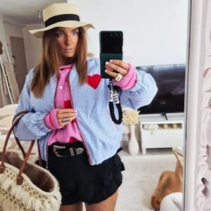 Une femme porte un blouson tendance casual bohème mi saison motif coeur rayée bleu et blanc pour la mi saison