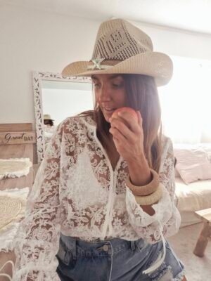 Une femme porte un chemisier en dentelle blanc bohème bohemianne