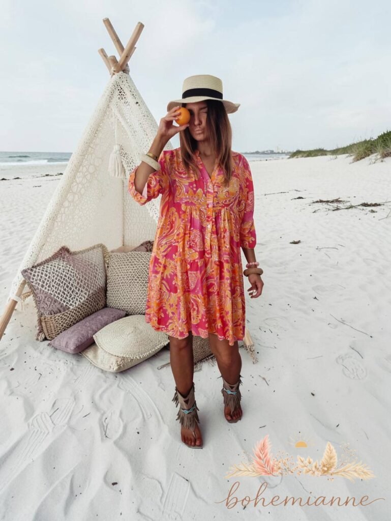 Robe bohème fluide imprimée rose et orange style californien portée sur la plage look été femme