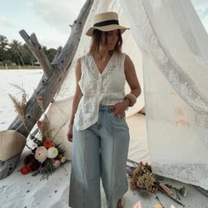 Jean femme coupe large bleu clair, longueur cheville effet coupé, style bohème chic décontracté.