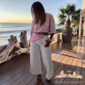 Jean femme 3/4 en coton blanc avec volants au bas des jambes, coupe fluide, style bohème chic, disponible en plusieurs tailles.